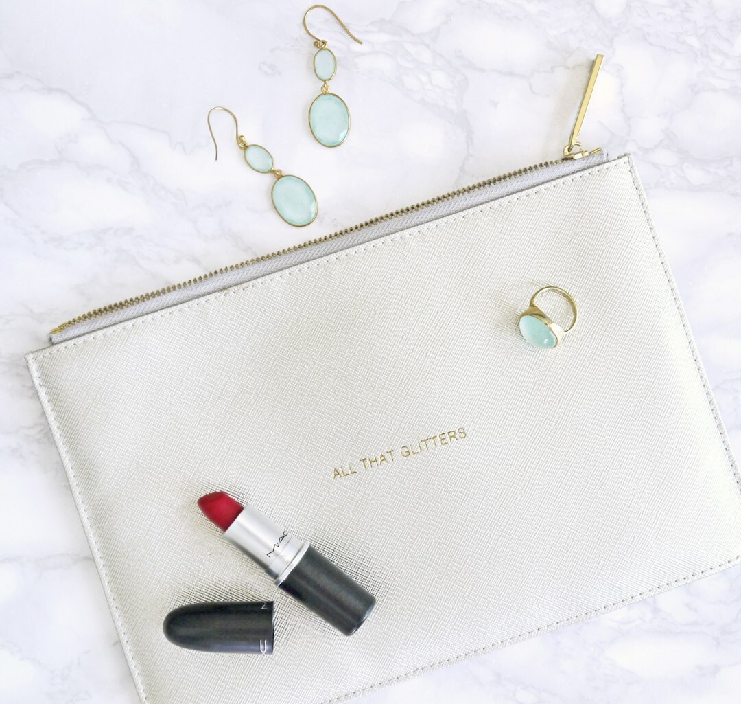 Flatlay of designer heels and a leather clutch on marble