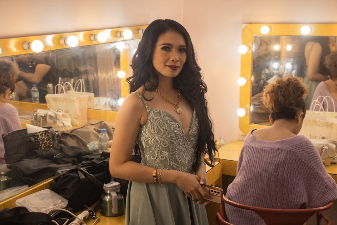 Stylist adjusting a model's dress backstage before a fashion show